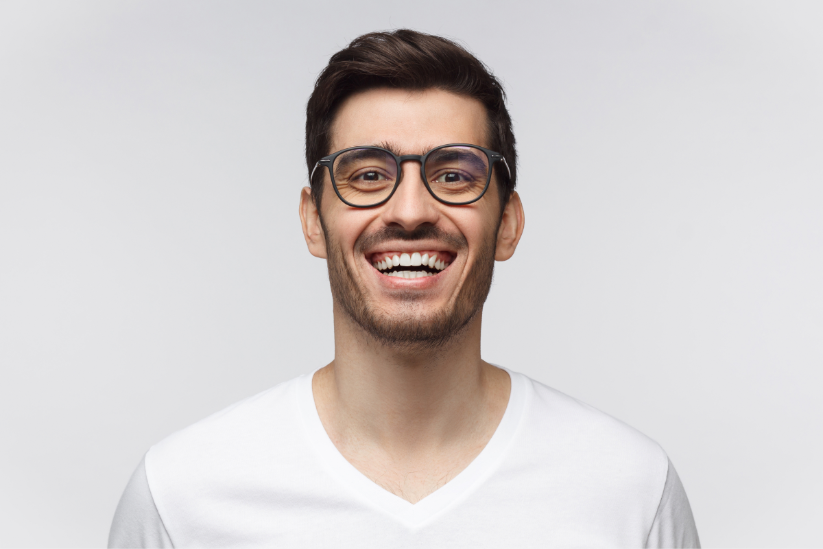 Man with glasses smiling confidently